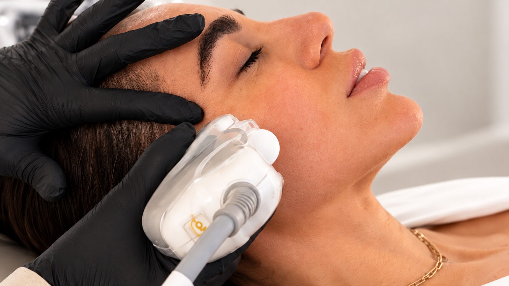 Paciente relaxada recebendo tratamento facial com ultrassom no consultório