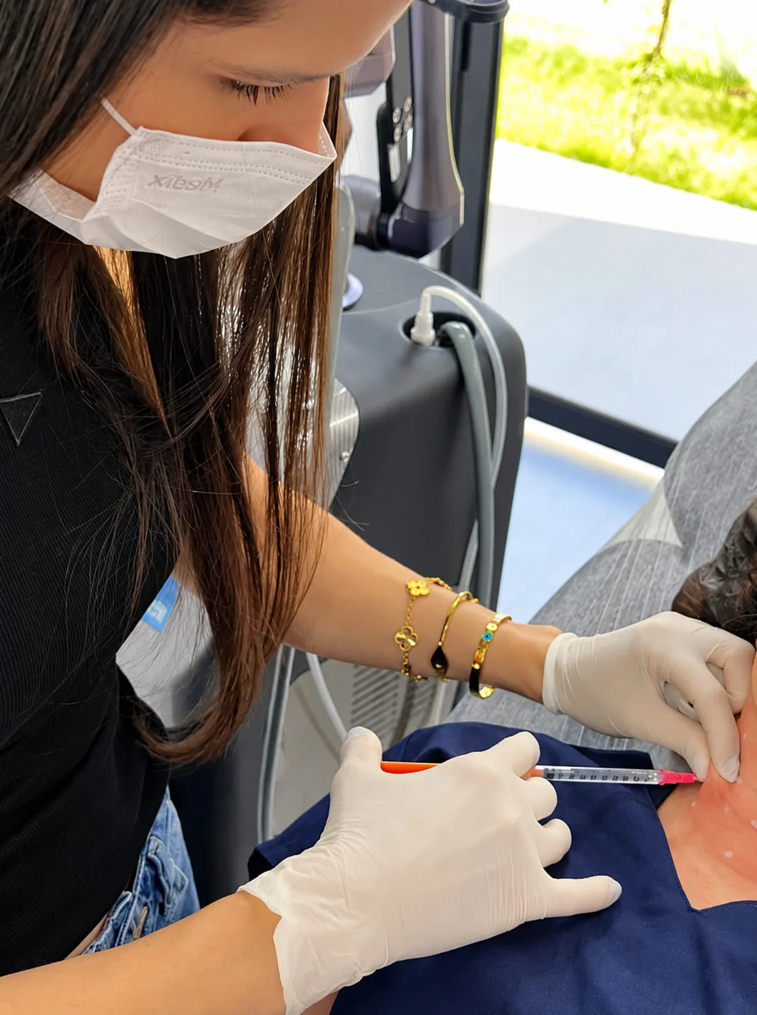 Dra. Ariela realizando procedimento no pescoço de um paciente